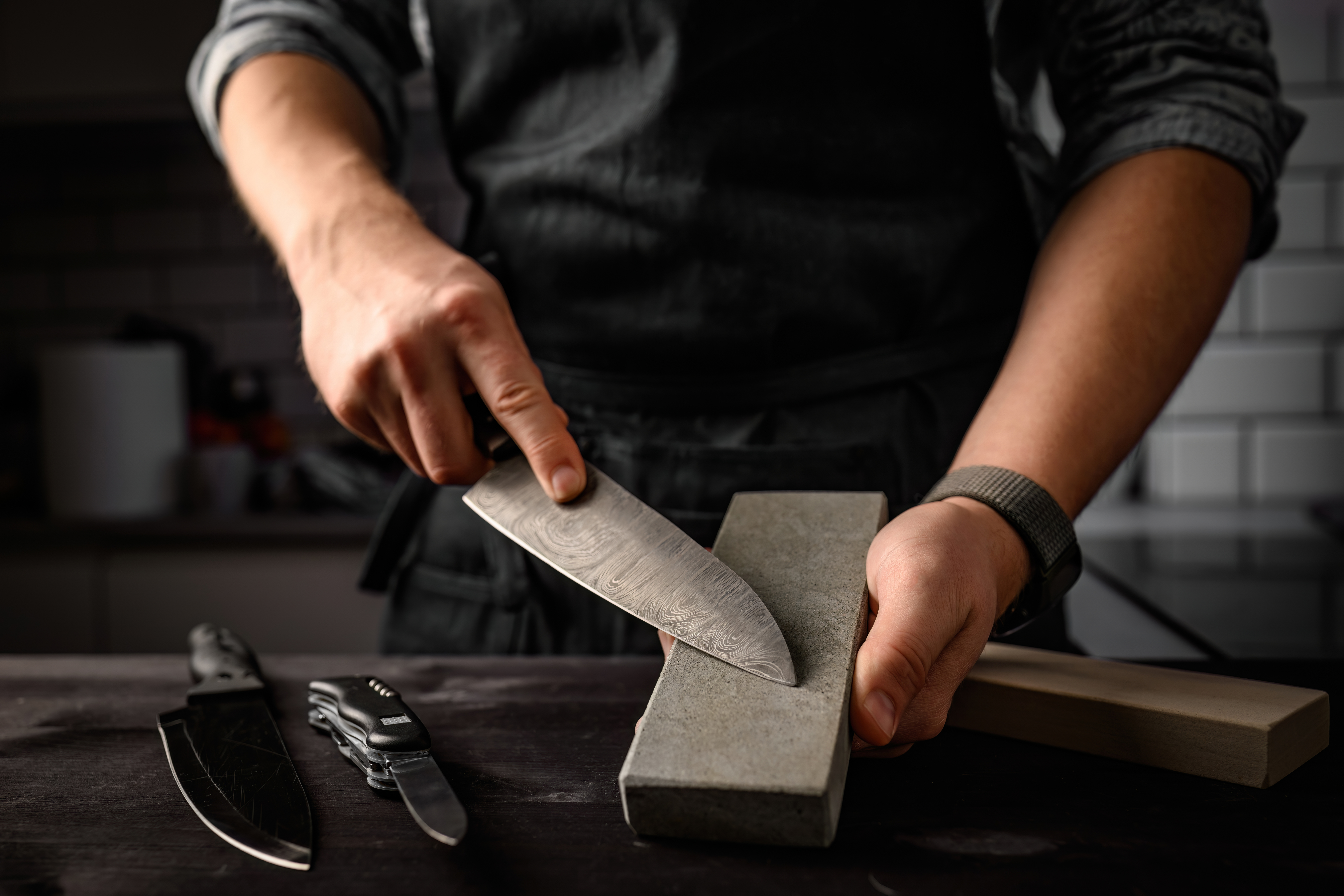Craftsman sharpening a knife with a sharpening stone